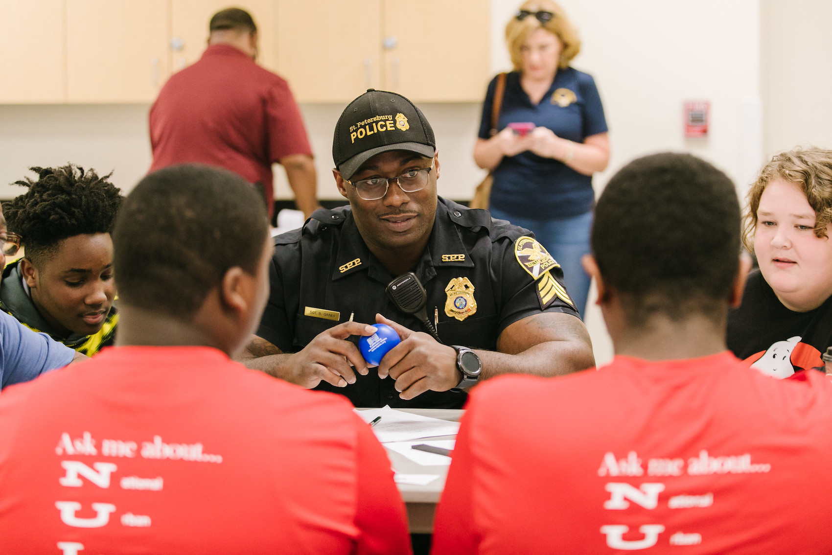 Police man talking to youth at discussion table